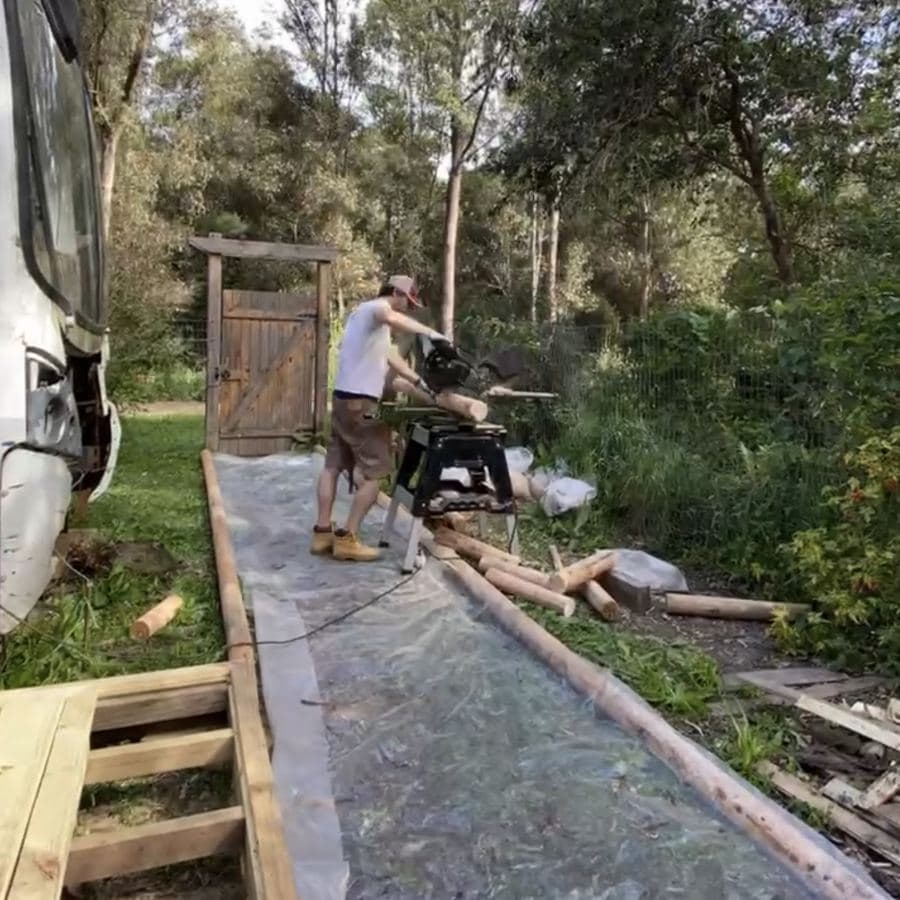 Alfo cortando los polines de eucalipto con una sierra ingletadora, junto al Bondi